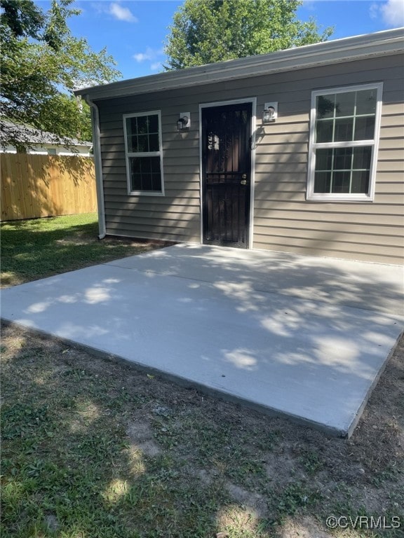 doorway to property featuring fence and a patio area
