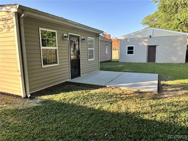 back of house featuring a yard, a patio, and an outdoor structure