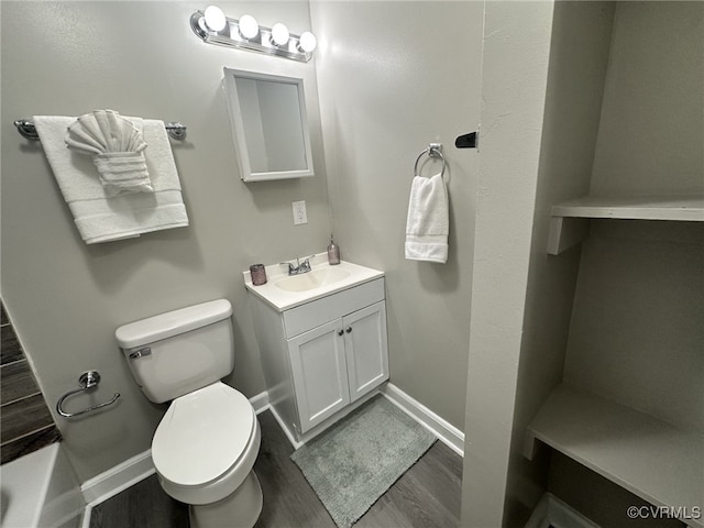 bathroom with wood finished floors, toilet, baseboards, and vanity