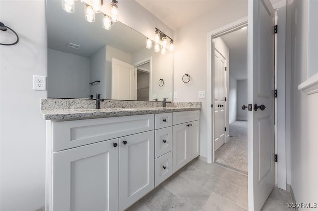 bathroom with double vanity and baseboards