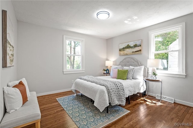 bedroom featuring baseboards and wood finished floors