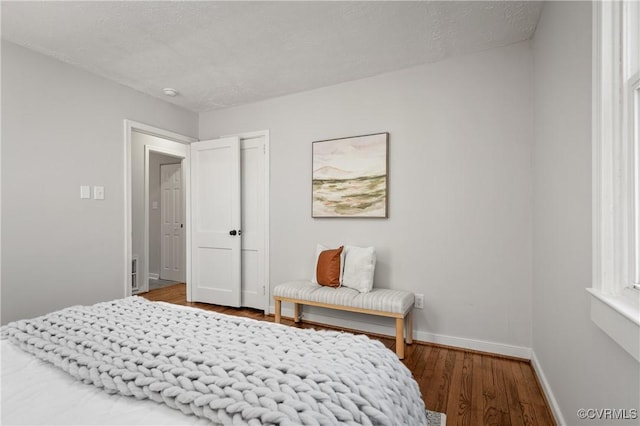 bedroom with baseboards and wood finished floors