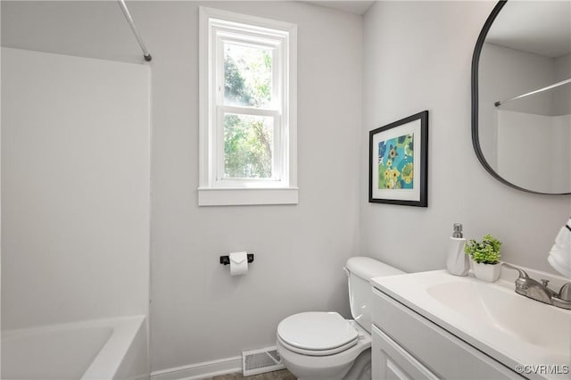 bathroom featuring toilet, baseboards, vanity, and shower / washtub combination