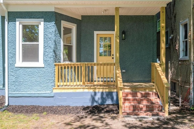 entrance to property with stucco siding and covered porch