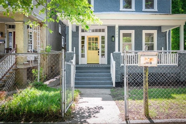 property entrance featuring a porch, fence, stucco siding, and a gate