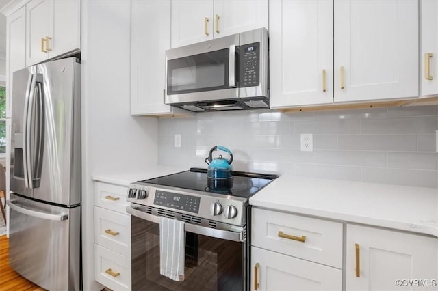 kitchen with appliances with stainless steel finishes, light countertops, white cabinetry, and tasteful backsplash