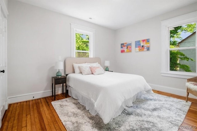 bedroom with baseboards and wood finished floors