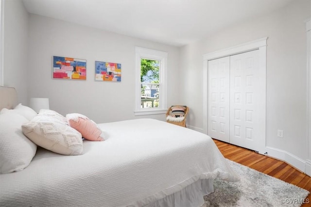 bedroom featuring wood finished floors, a closet, and baseboards