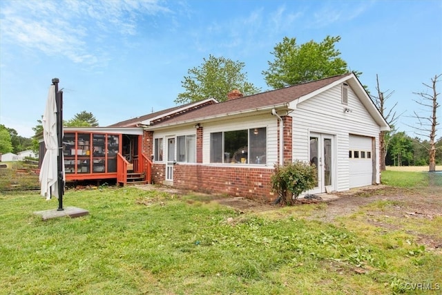 view of front of home featuring a sunroom, brick siding, a chimney, and a front yard