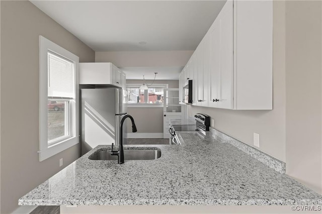 1506 5th St, Victoria, VA 23974 - kitchen with a sink, stainless steel appliances, light stone counters, and white cabinetry