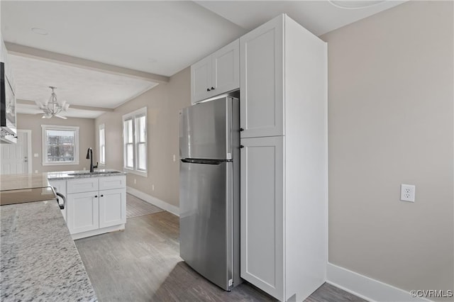 1506 5th St, Victoria, VA 23974 - kitchen with freestanding refrigerator, a sink, baseboards, wood finished floors, and beamed ceiling