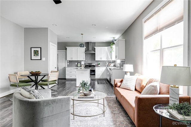 living area with dark wood finished floors, healthy amount of natural light, baseboards, and recessed lighting