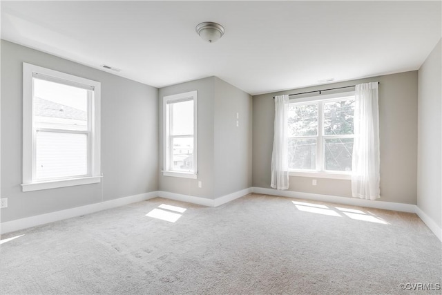 carpeted spare room featuring baseboards