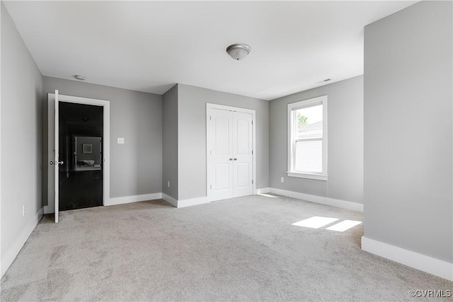 unfurnished bedroom featuring carpet flooring, baseboards, and a closet