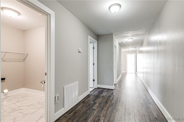 hallway featuring baseboards and dark wood-style floors