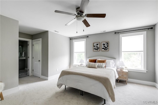bedroom with light colored carpet, baseboards, connected bathroom, and a ceiling fan