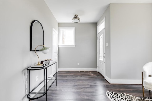 entryway with dark wood finished floors and baseboards