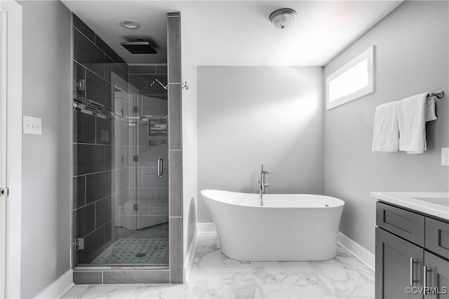 full bath with baseboards, a stall shower, marble look tile flooring, a freestanding tub, and vanity