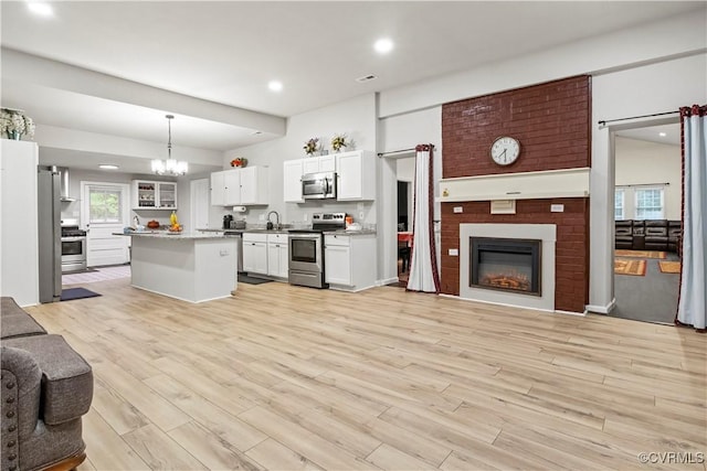 10717 Greenwood Rd, Henrico, VA 23059 - kitchen with appliances with stainless steel finishes, open floor plan, a sink, a large fireplace, and recessed lighting