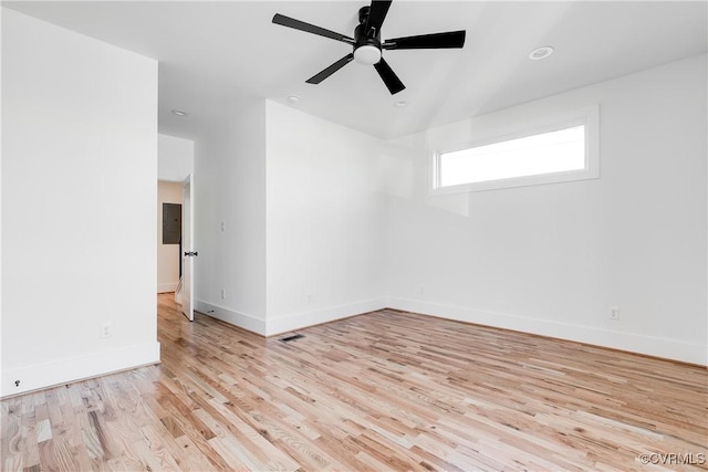 unfurnished room with light wood-style floors, baseboards, a ceiling fan, and electric panel