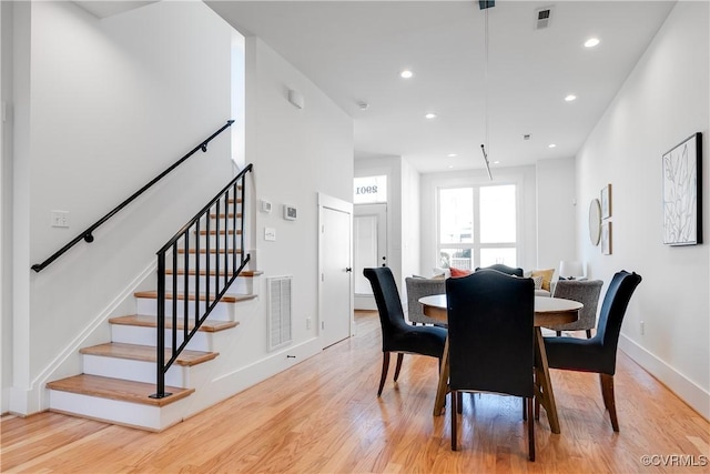 dining area with light wood-style floors, stairway, baseboards, and recessed lighting
