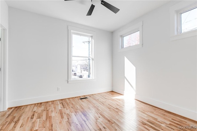 empty room featuring wood finished floors, baseboards, and a ceiling fan