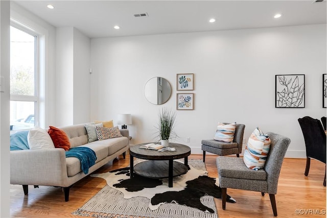 living area featuring healthy amount of natural light, light wood-type flooring, and recessed lighting