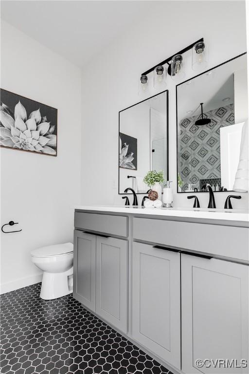 full bath with double vanity, toilet, baseboards, a shower, and tile patterned floors