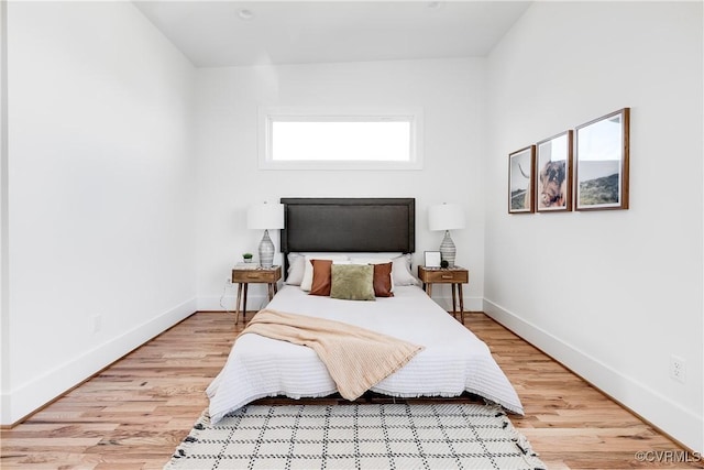 bedroom with baseboards and light wood-type flooring