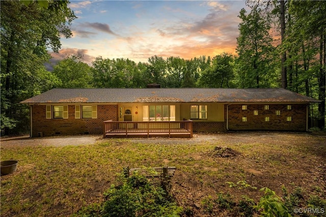 back of house with a wooden deck, a yard, brick siding, and a chimney
