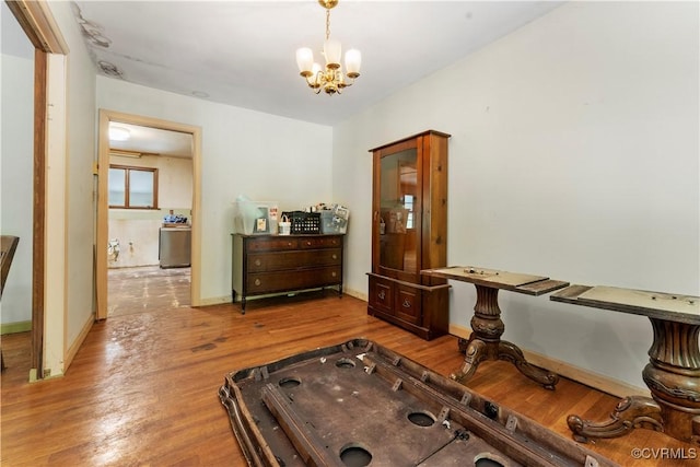 rec room featuring a chandelier, wood finished floors, and baseboards