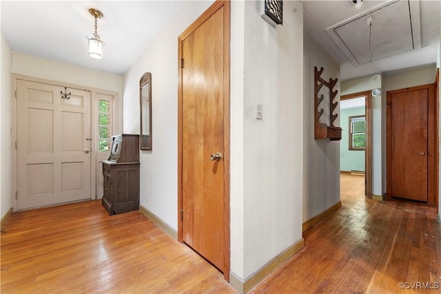 entrance foyer featuring light wood-type flooring, plenty of natural light, and baseboards