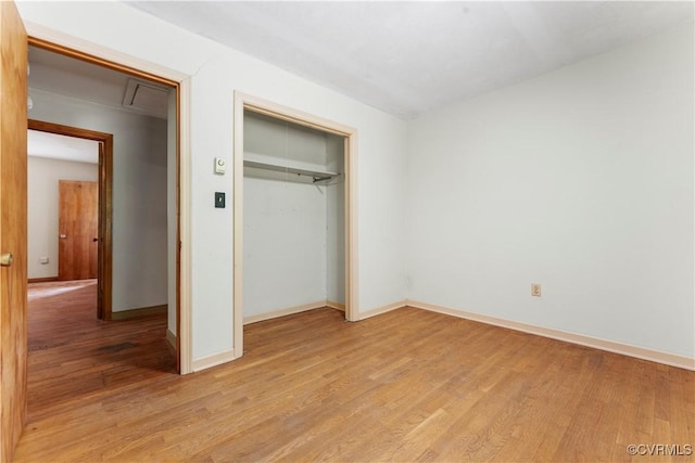 unfurnished bedroom with light wood-style floors, a closet, and baseboards