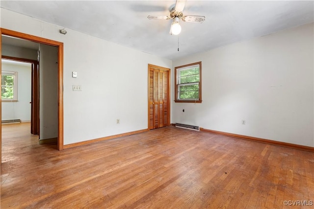 unfurnished room with healthy amount of natural light, ceiling fan, light wood-style floors, and baseboards