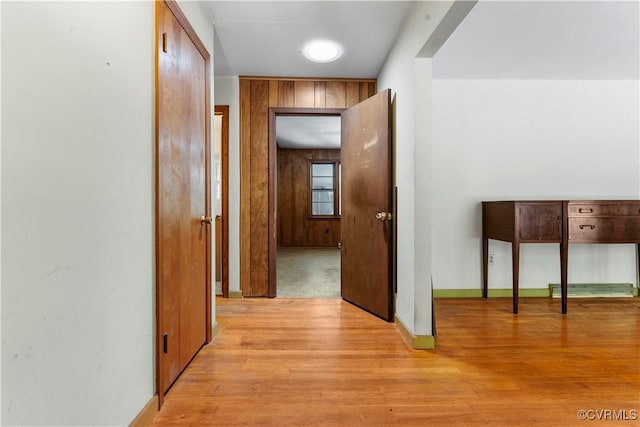 hall with light wood-style floors and baseboards