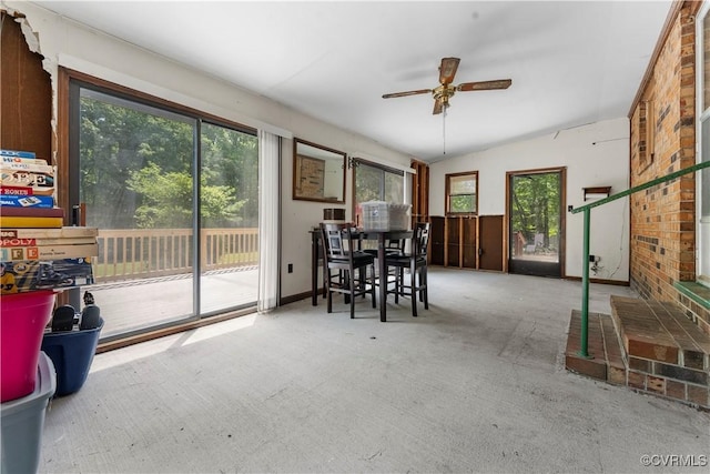 dining space with a ceiling fan, carpet flooring, and vaulted ceiling