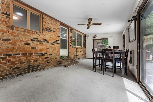 sunroom featuring ceiling fan, outdoor dining area, and entry steps