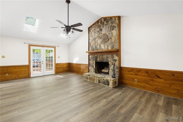 9606 Ladue Rd, North Chesterfield, VA 23237 - unfurnished living room with wainscoting, vaulted ceiling, wooden walls, a skylight, and a ceiling fan