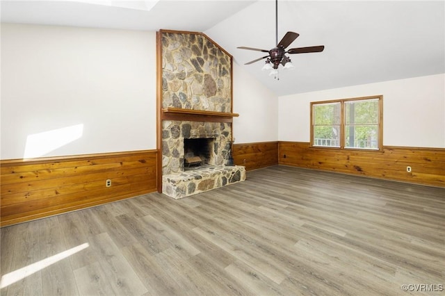 9606 Ladue Rd, North Chesterfield, VA 23237 - unfurnished living room featuring wainscoting, wood walls, wood finished floors, lofted ceiling, and a stone fireplace