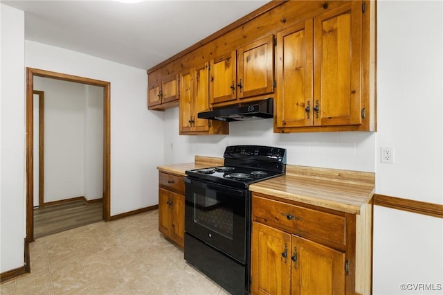 9606 Ladue Rd, North Chesterfield, VA 23237 - kitchen with black electric range oven, under cabinet range hood, brown cabinets, light countertops, and baseboards