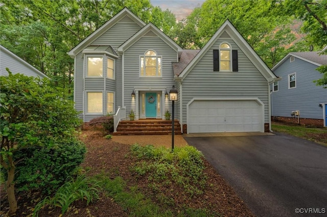 traditional home with asphalt driveway and a garage