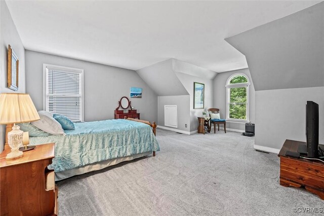 carpeted bedroom with lofted ceiling and baseboards