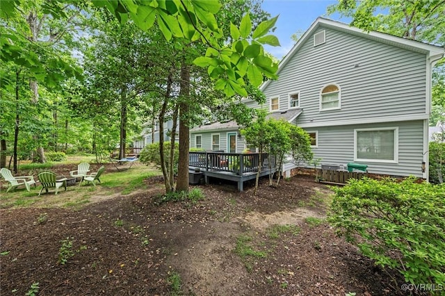 rear view of property with a fire pit and a wooden deck