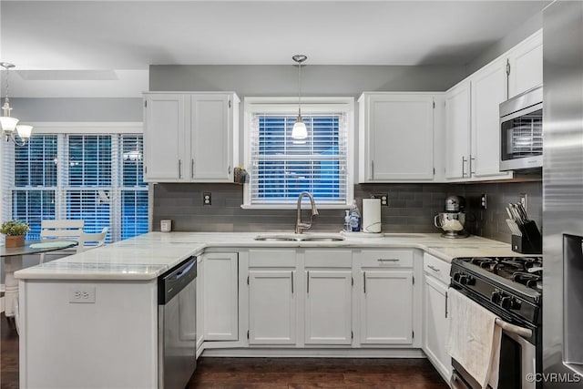 kitchen featuring a sink, stainless steel appliances, a peninsula, and white cabinets