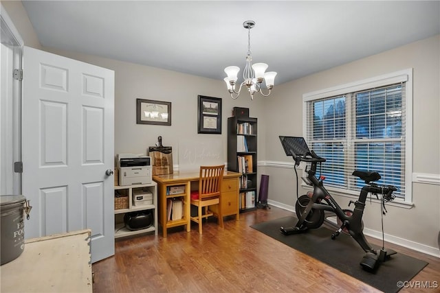 workout area with a chandelier, wood finished floors, and baseboards