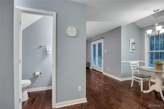 dining space featuring a chandelier, wood finished floors, and baseboards