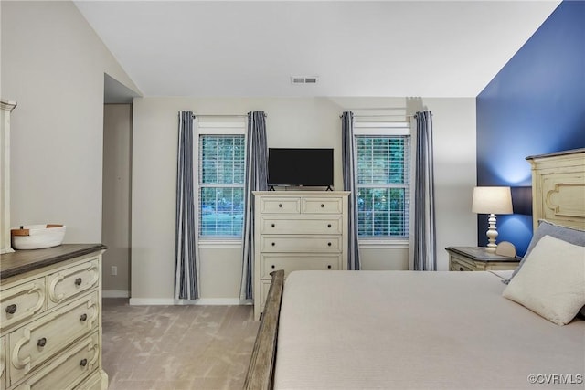 bedroom with baseboards and light colored carpet