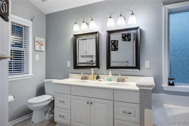 bathroom featuring toilet, double vanity, and a bath