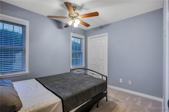 bedroom with baseboards, carpet flooring, a closet, and ceiling fan