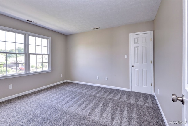unfurnished room featuring carpet floors, baseboards, and a textured ceiling